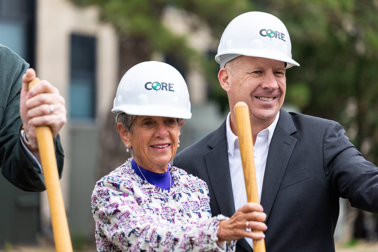 Guests in hard hats holding gold shovels at the groundbreaking