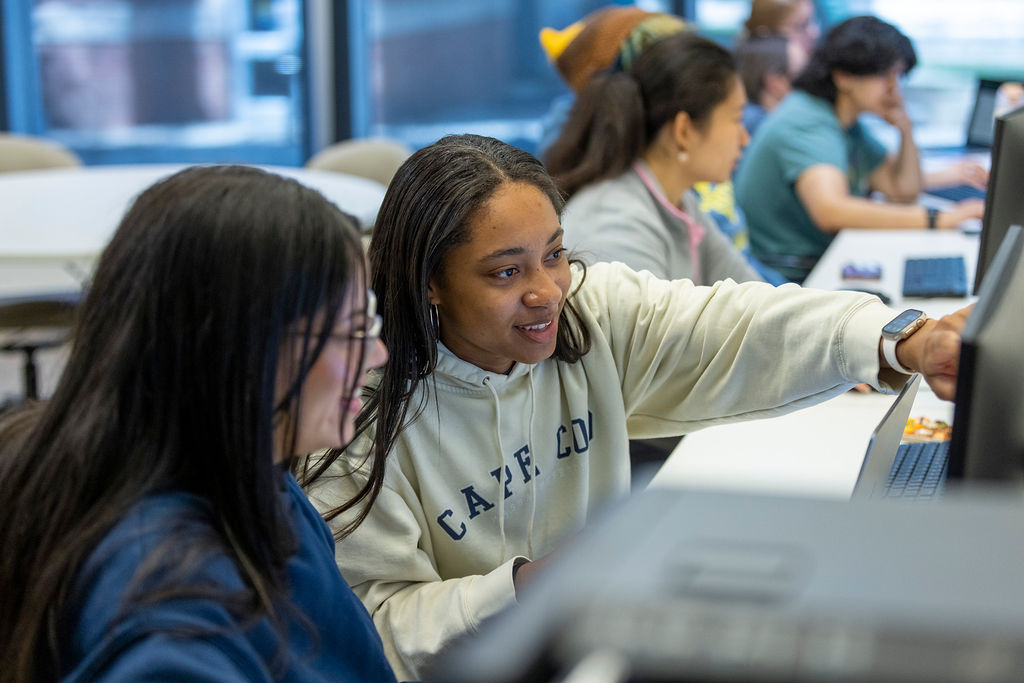 Illinois Wesleyan students collaborating at computers in a lab