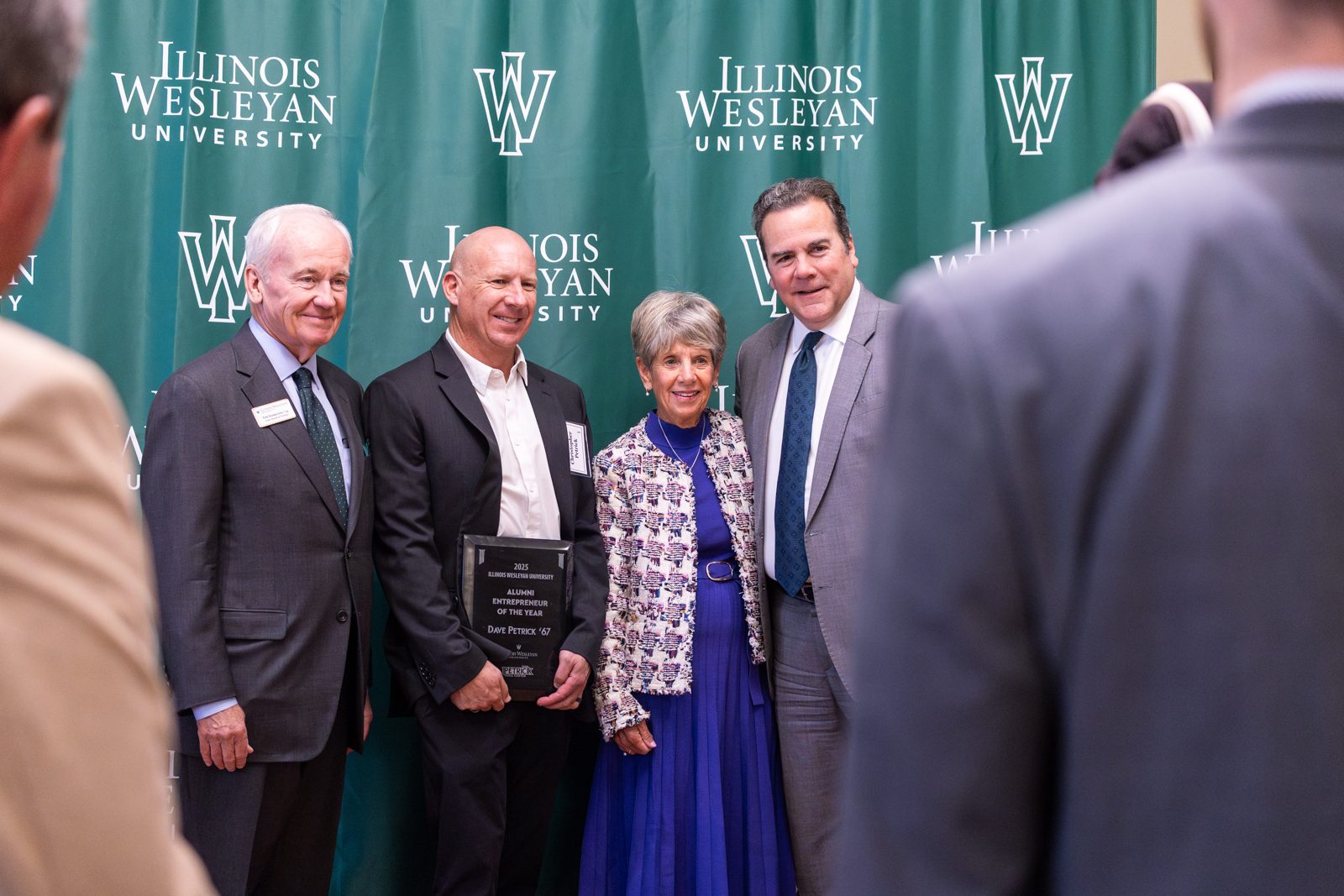 Honorees with university leaders in front of an Illinois Wesleyan backdrop