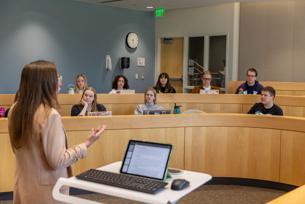 An Illinois Wesleyan professor leading a discussion with students in a lecture hall