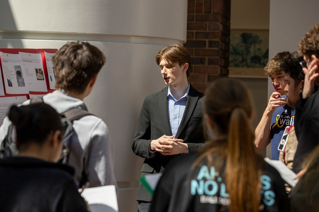 An Illinois Wesleyan student presenting his research to classmates